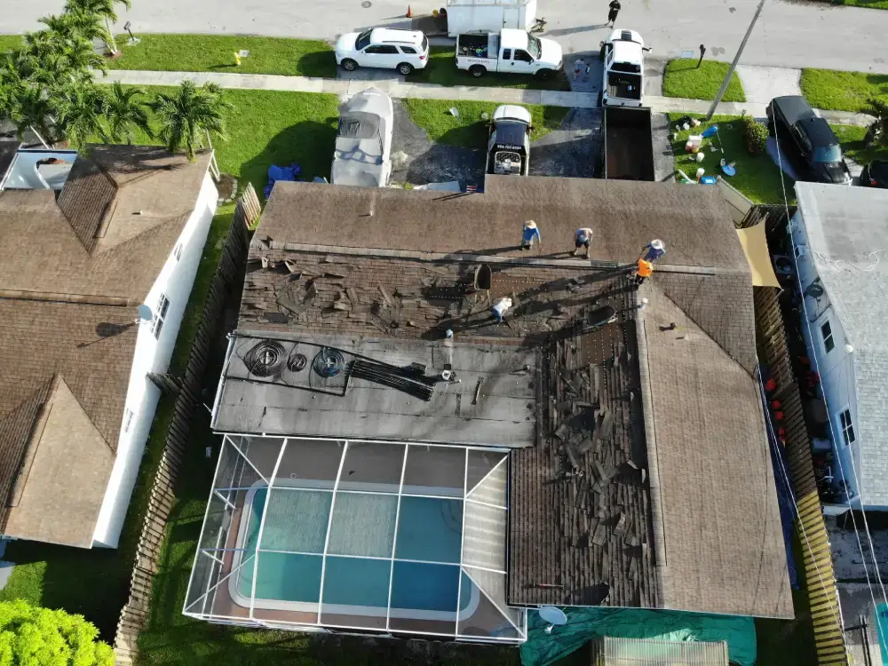 Roof tear-off in progress on a single-family home with pool enclosure